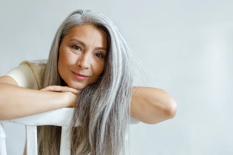 Attractive woman resting head on hands on chair